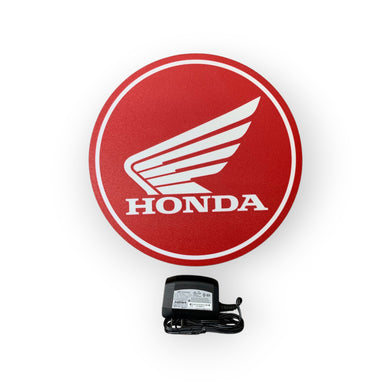 Red Honda led sign with a power adapter on a white background