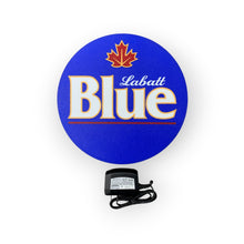 Load image into Gallery viewer, Labatt Blue logo on a blue circular LED indoor sign with a power adapter below.