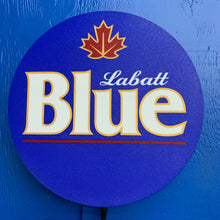 Load image into Gallery viewer, Labatt Blue logo on a blue background on a LED indoor sign hanging on a wall.