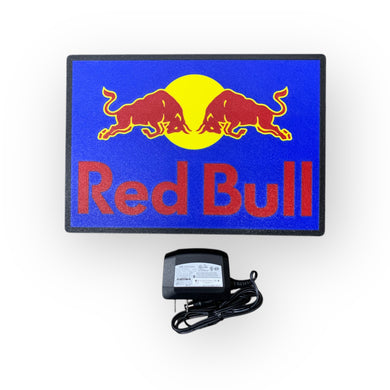 Red Bull led indoor sign on a blue background with an adapter below