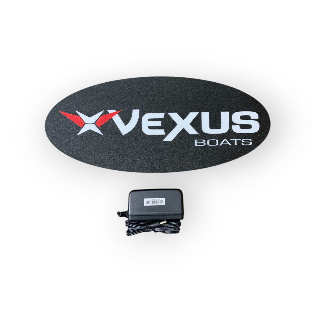 Vexus Boats led sign on a black oval with a power adapter below on a white background